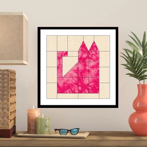 May include: A framed pink and white quilt block with a geometric design. The block is made up of squares and triangles, and it is set against a white background.