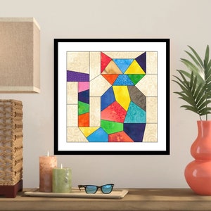 May include: A colourful abstract cat illustration made of geometric shapes in a variety of colours, including red, orange, yellow, green, blue, purple, and pink. The cat is framed in a black frame.