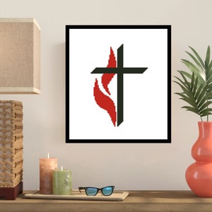 May include: A framed print of a black cross with a red flame behind it. The cross and flame are stylized and are on a white background.
