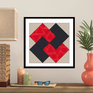 Op de afbeelding: Ingelijst kunstwerk met een geometrisch ontwerp van overlappende rode en zwarte vierkanten op een beige gestippelde achtergrond. Het kunstwerk wordt tentoongesteld op een houten oppervlak met kaarsen, een dienblad en een zonnebril.