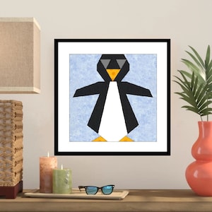 Puede incluir: Una impresión de arte geométrico enmarcada de un pingüino con gafas de sol sobre un fondo azul.