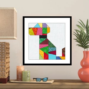 May include: A framed print of a colourful geometric dog design. The dog is made up of various shapes and patterns in shades of red, green, blue, yellow, pink, and brown.