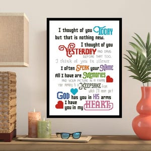May include: A framed cross-stitch artwork with a black border. The text reads "I thought of you TODAY... I have you in my HEART." The words are in various colors, including blue, red, and green. The artwork is displayed on a wooden surface.