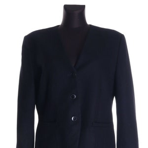 Könnte beinhalten: Ein schwarzer Blazer mit V-Ausschnitt und drei Knöpfen. Der Blazer hat zwei Taschen auf der Vorderseite.
