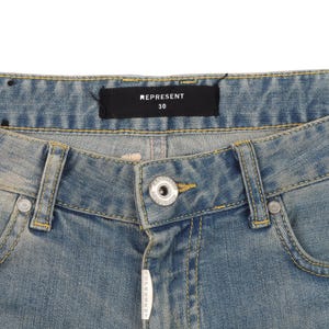 May include: A pair of light blue denim jeans with a yellow stitch detail. The waistband has a black label with the text "REPRESENT 30".