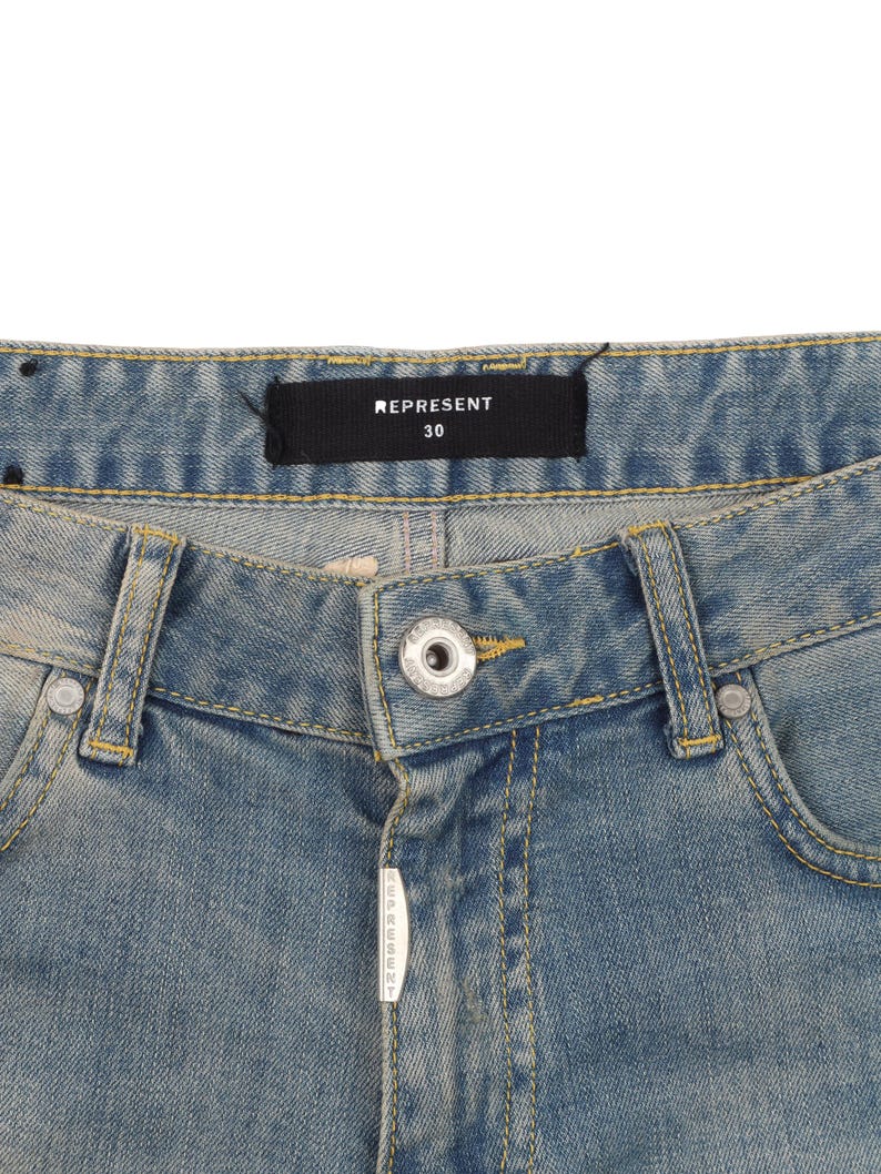May include: A pair of light blue denim jeans with a yellow stitch detail. The waistband has a black label with the text "REPRESENT 30".