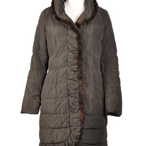 May include: A long, brown quilted coat with a fur trim around the collar and down the front. The coat has a slightly ruffled hem.