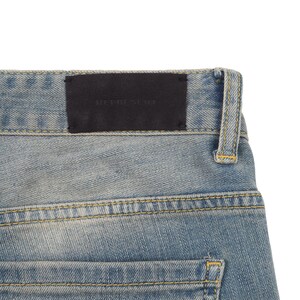 May include: A pair of blue denim jeans with a black leather patch that says "REPRESENT" on the back waistband.