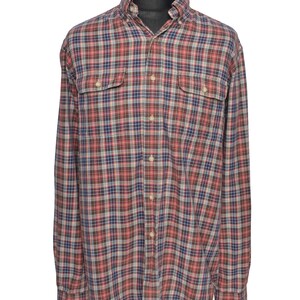May include: A long-sleeved, checked shirt in red, brown, blue, and white. It features two chest pockets and a button-down collar. The fabric looks to be a medium-weight cotton or blend, suitable for casual wear.