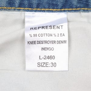 May include: A white tag with black text that reads "REPRESENT % 98 COTTON % 2 EA KNEE DESTROYER DENIM INDIGO L-2460 SIZE:30"