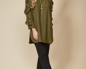 May include: A green long-sleeved blouse with ruffled sleeves and a round neckline. The blouse is paired with black pants and black platform sandals.
