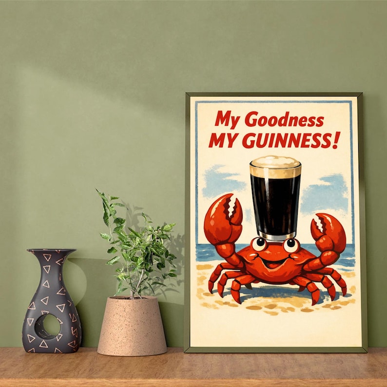 May include: A framed print featuring a cartoon crab with a pint of Guinness balanced on its head. The crab is red with a smiling face, set against a beach scene. The text "My Goodness MY GUINNESS!" is displayed at the top.
