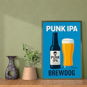 May include: A framed poster with a blue background displays "PUNK IPA" in white. A black beer bottle and a pint of beer are illustrated below. The text "BREWDOG" is at the bottom. A decorative vase and a potted plant are on the left.