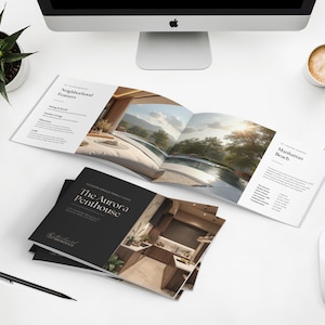 May include: A top-down view of a white desk with a computer, coffee cup, and a smartphone. Brochures titled "The Aurora Penthouse" and "Manhattan Beach" are open. A pen, mouse, and a potted plant are also on the desk.