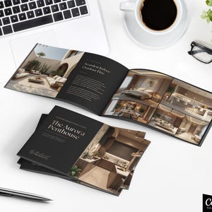 May include: An open brochure titled "The Aurora Penthouse" with interior design images, a laptop, a cup of coffee, glasses, and a pen on a white surface. The brochure features images of modern home interiors.