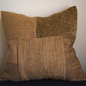 May include: A brown and beige patchwork cushion with a textured fabric.