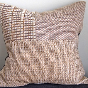May include: A brown and beige patterned throw pillow with a woven texture.