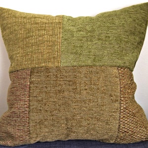Peut inclure: Un coussin carré en patchwork avec un motif brun, vert et rouge. Le coussin est fait d'un tissu texturé et a un léger brillant.
