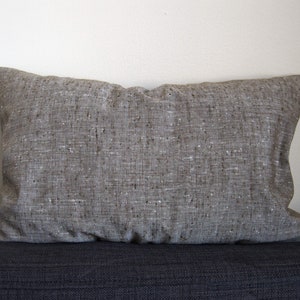 May include: A brown rectangular cushion with a textured fabric surface.