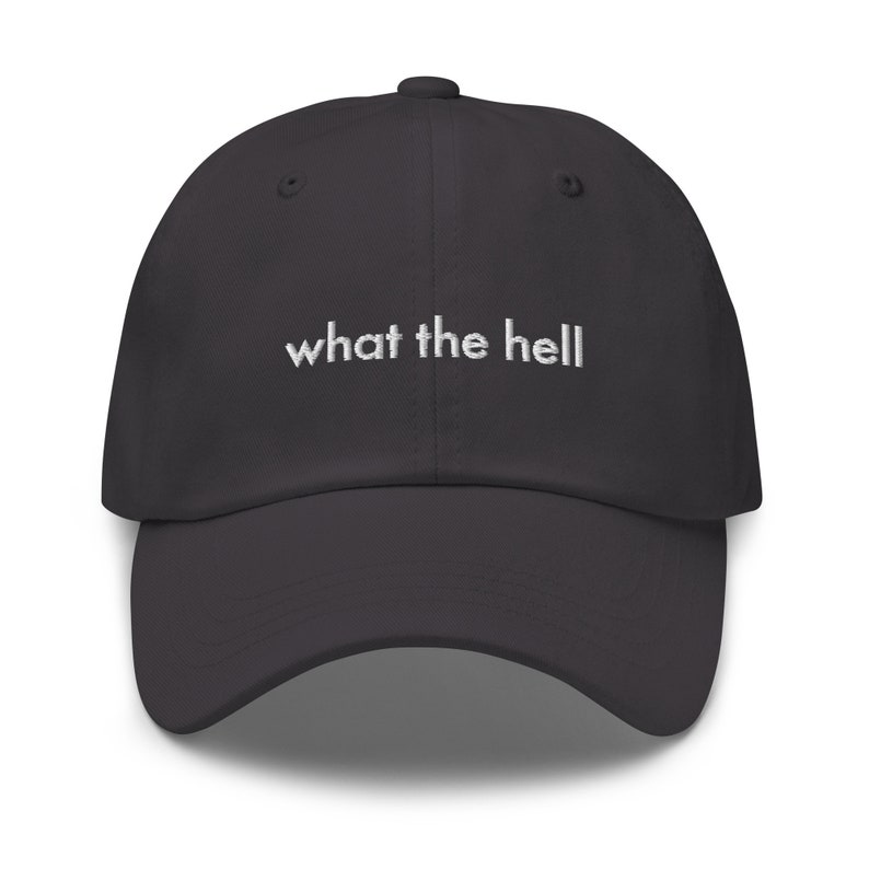 Puede incluir: Una gorra de b&eacute;isbol gris oscuro con la frase "what the hell" bordada en blanco en la parte delantera.