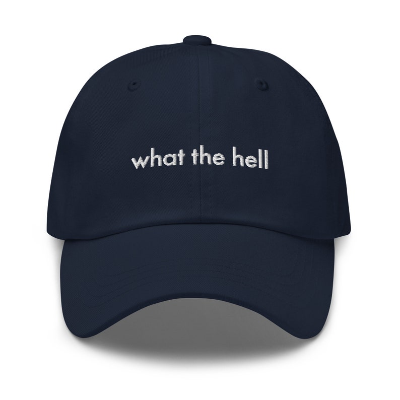 Puede incluir: Una gorra de b&eacute;isbol azul marino con texto bordado en blanco que dice "what the hell".