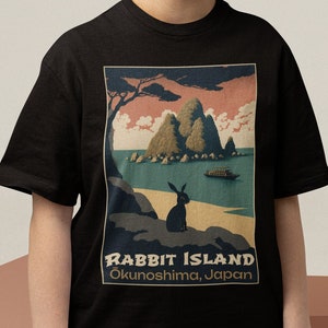 May include: Black t-shirt with a vintage-style graphic of a rabbit on an island. The graphic says "Rabbit Island, Okunoshima, Japan".