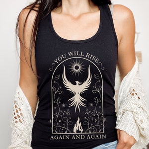 May include: Black tank top with a graphic of a phoenix rising from flames and the text "You Will Rise Again and Again".