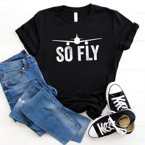 May include: Black t-shirt with a white airplane graphic and the text "SO FLY" in white.