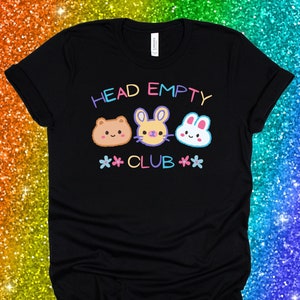 May include: Black t-shirt with the text "HEAD EMPTY CLUB" in rainbow colours. Three cartoon animal faces are above the text: a brown bear, a purple bunny, and a white bunny.