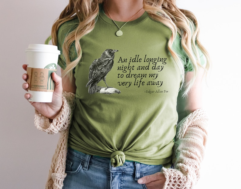 May include: Green t-shirt featuring a black raven illustration and a quote from Edgar Allan Poe: "An idle longing night and day to dream my very life away".