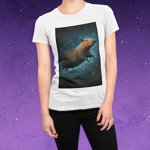 May include: White t-shirt with a graphic of a capybara floating in space with stars and a blue nebula background.