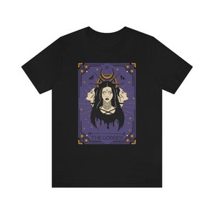 May include: Black t-shirt with a graphic of a tarot card featuring a woman with three faces and the text "The Goddess".