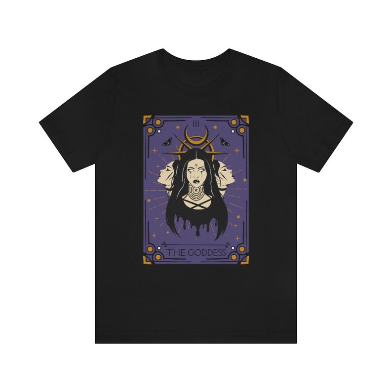 May include: Black t-shirt with a graphic of a tarot card featuring a woman with three faces and the text "The Goddess".