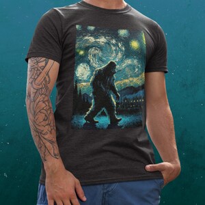 Może przedstawiać: Szary t-shirt z nadrukiem Bigfoota idącego przez nocne, gwieździste niebo, przypominające 'Gwiezdną noc' Vincenta van Gogha.