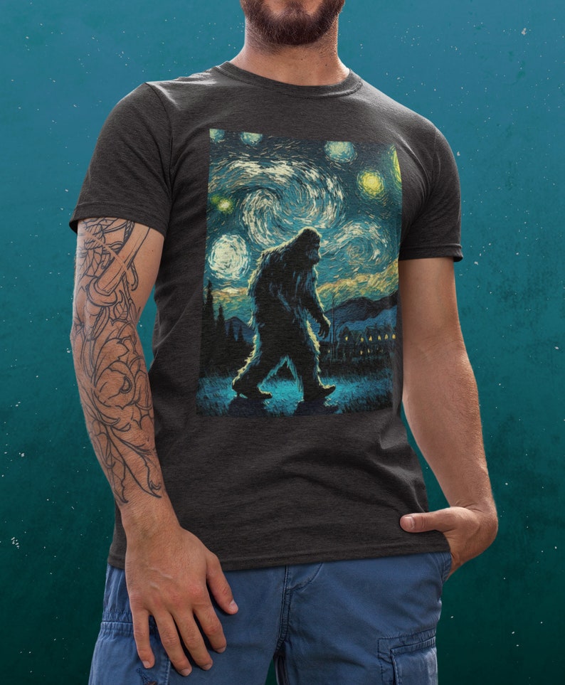 Może przedstawiać: Szary t-shirt z nadrukiem Bigfoota idącego przez nocne, gwieździste niebo, przypominające 'Gwiezdną noc' Vincenta van Gogha.