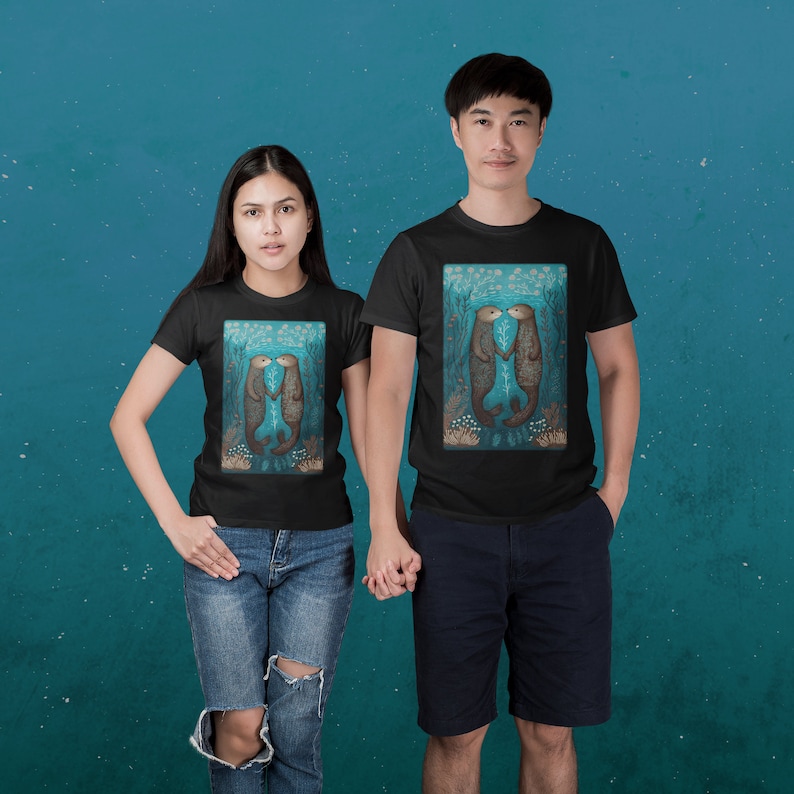 May include: Two people wearing black t-shirts with a graphic of two otters kissing underwater. The otters are brown and the background is blue with white accents.