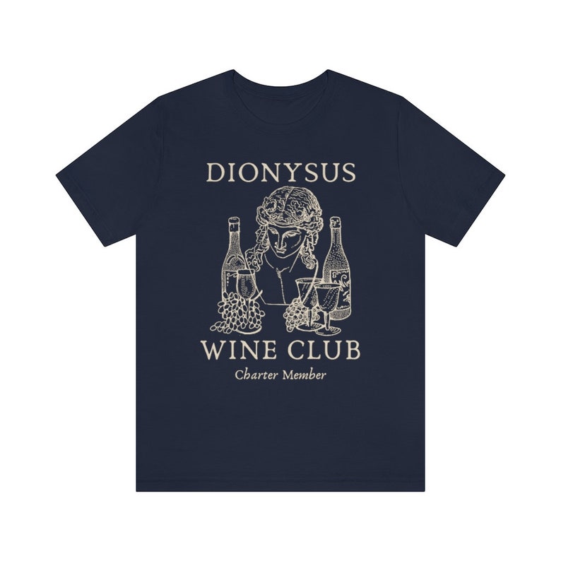 May include: Navy blue t-shirt with a white graphic of a bust of Dionysus with grapes and wine bottles. The text "Dionysus Wine Club Charter Member" is printed below the graphic.