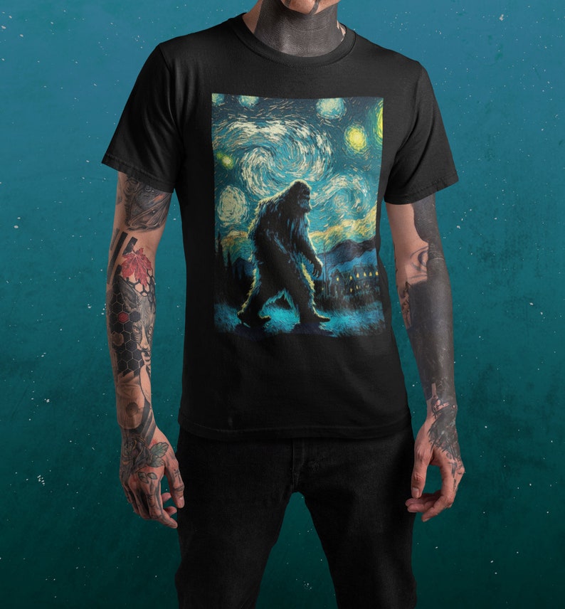 Może przedstawiać: Czarny T-shirt z nadrukiem graficznym przedstawiającym Bigfoota idącego przez nocne, gwieździste niebo, przypominające 'Gwiezdną noc' Vincenta van Gogha.