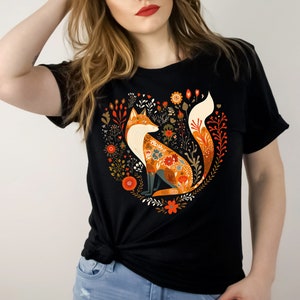 May include: Black t-shirt with a colorful fox illustration surrounded by flowers in a heart shape.