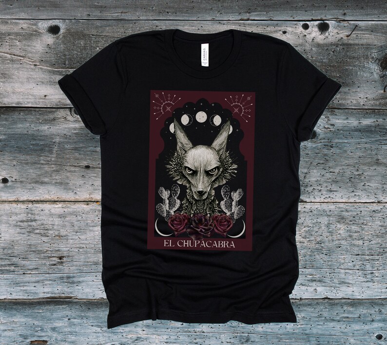May include: Black t-shirt with a graphic print of a wolf-like creature with red roses and the text "EL CHUPACABRA".