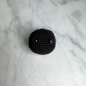 Small black hole toy crocheted with yarn
