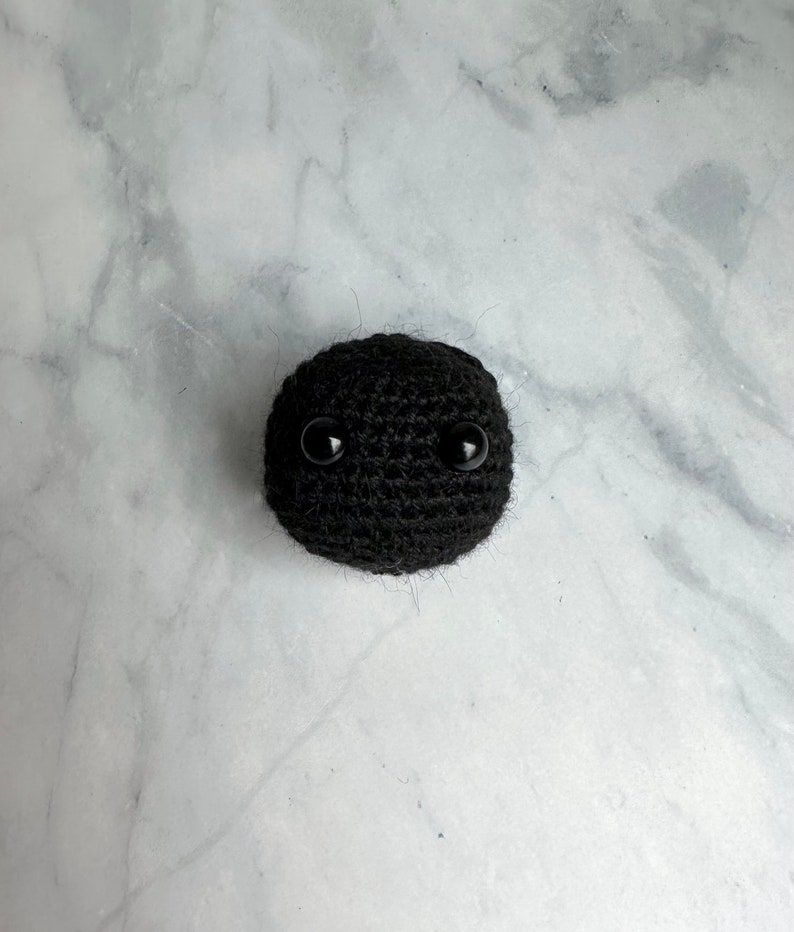 Small black hole toy crocheted with yarn