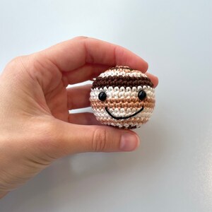 Crocheted Jupiter planet plush with an embroidered smile and eyes.
