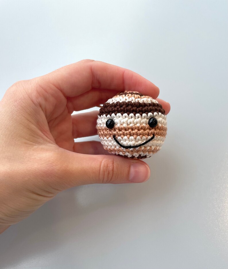 Crocheted Jupiter planet plush with an embroidered smile and eyes.