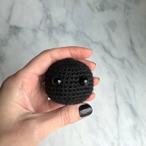 Blackhole toy crocheted with yarn held in woman's hand