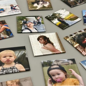 May include: A collection of square photo magnets with various images, including a family portrait, a wedding photo, a child in a dress, and a dog.