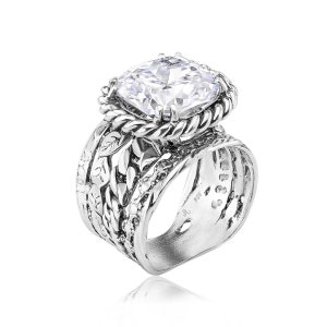 May include: A silver ring with a large, clear, square-shaped gemstone set in a twisted rope design. The band of the ring is decorated with a leafy pattern.