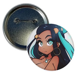 May include: A round button featuring a cartoon illustration of a woman with long black hair, blue eyes, and a turquoise and white outfit. The woman is wearing large gold hoop earrings and a necklace with a turquoise pendant.