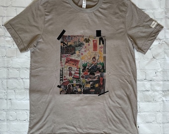 May include: A grey t-shirt with a collage print of a city scene. The print features a variety of images, including buildings, people, and street signs. The print is surrounded by a black border.