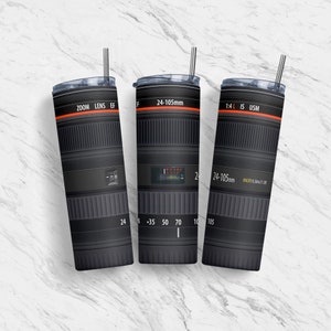 May include: Three black and silver camera lens tumblers with red text. The tumblers feature the text "ZOOM LENS EF", "24-105mm", and "1:4L IS USM".